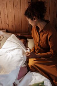 mother waking her daughter to administer flu and cold treatment